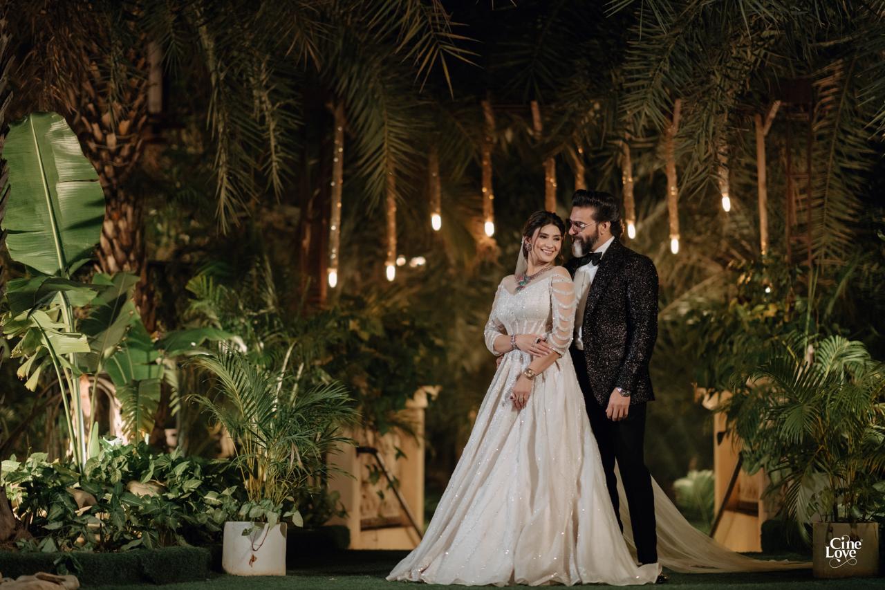 A couple celebrating together in an ivory embroidered gown and black tuxedo