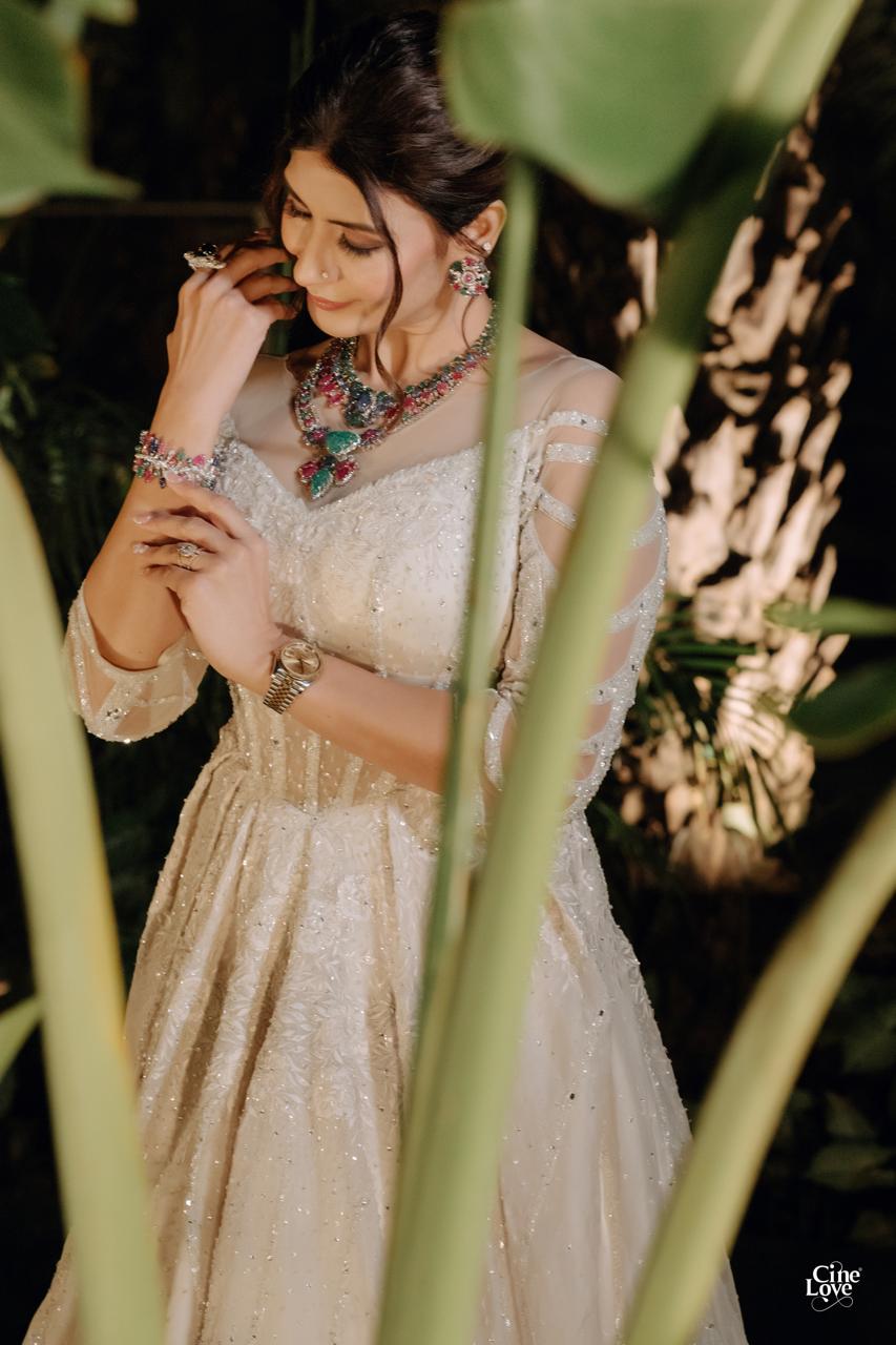 A close portrait showing the handwork and jewellery of an ivory evening ensemble